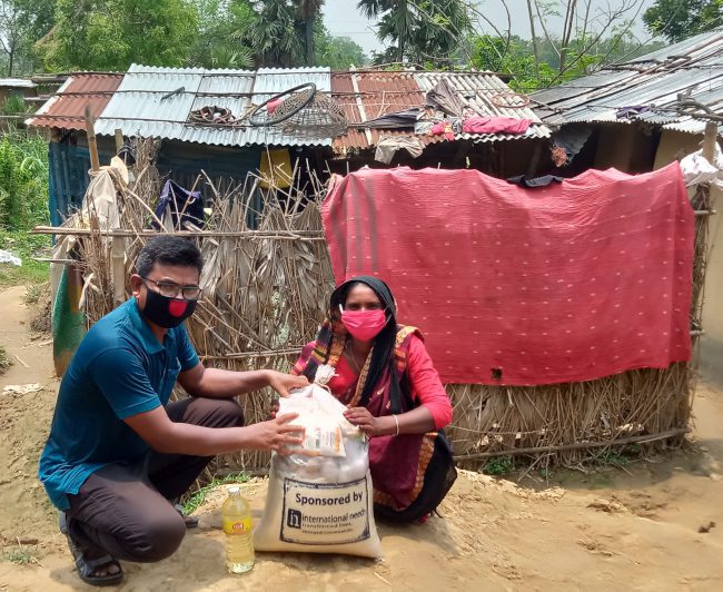 Kolegové z bangladéšské International Needs rozdávají balíčky s potravinami a hygienickými prostředky.