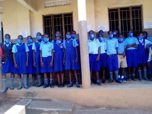 Ugandské děti si udělaly fotku v rouškách před svou školou.