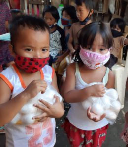 Děti si za dodržení protipandemických opatření vyzvedávají balíček potravinové pomoci.