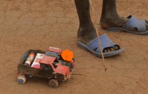Autíčko na dálkové ovládáni vyrobené z odpadků dítětem z Jižního Súdánu.