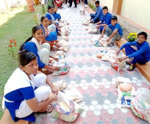 Žáci školy přijímají potravinovou pomoc pro svou rodinu.