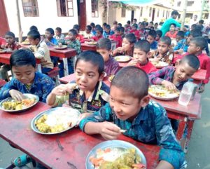 Chlapci z dětského domova Bethany si pochutnávají na slavnostním menu podávaném ve venkovní jídelně.