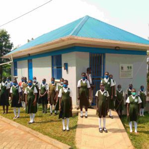 Studentky školy v Ugandě pózují před budovou nových toalet.