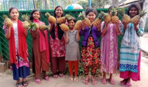 Děvčata z dětského domova Savar se radují z vlastní úrody ananasů.