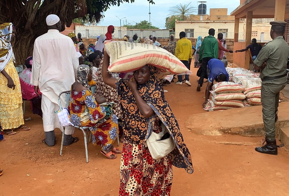 Žena si odnáší pytel rýže – potravinovou pomoc, kterou uprchlíkům rozdává organizace International Needs.