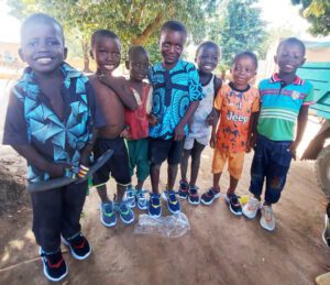 Děti z Burkiny Faso ukazují hrdě své nové boty.