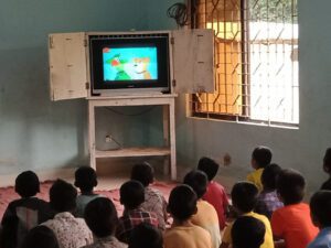 Chlapci z dětského domova sledují pohádku v televizi.