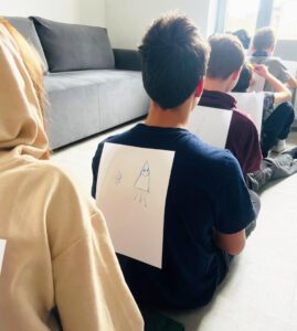 Děti hrají psanou tichou poštu.